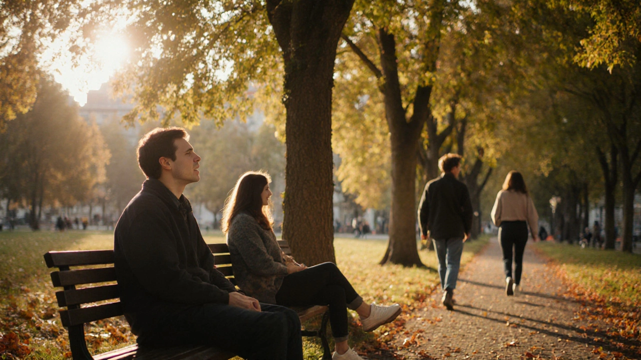 Skupina lidí v parku: jeden dýchá, druhý mluví s přítelem, třetí se pomalu prochází pod stromy v zlatém světle.